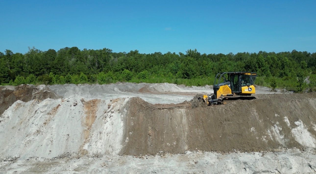 Dozer grading and shaping dirt on a Triple H job site